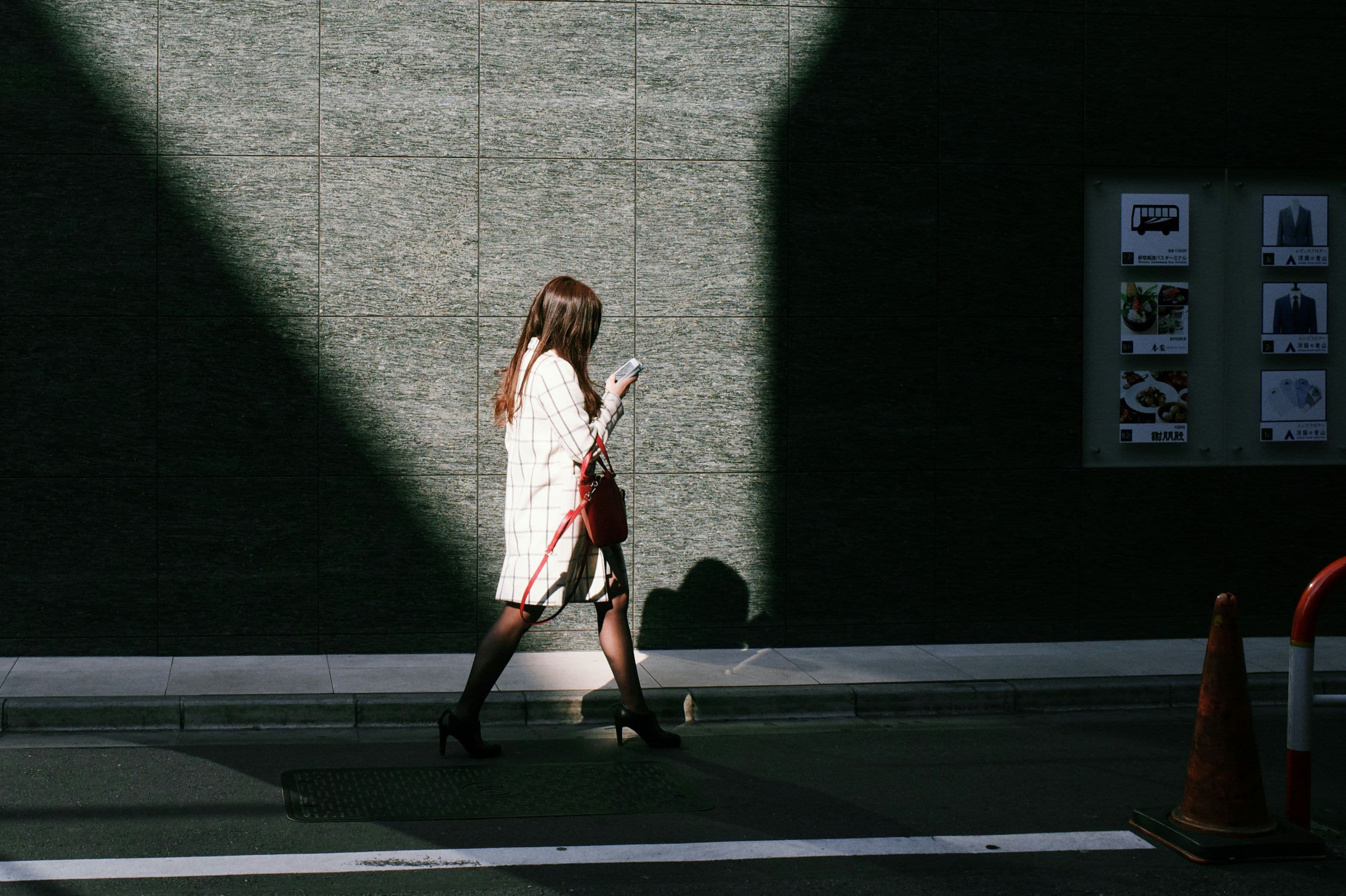 Business person walking on street looking at phone
